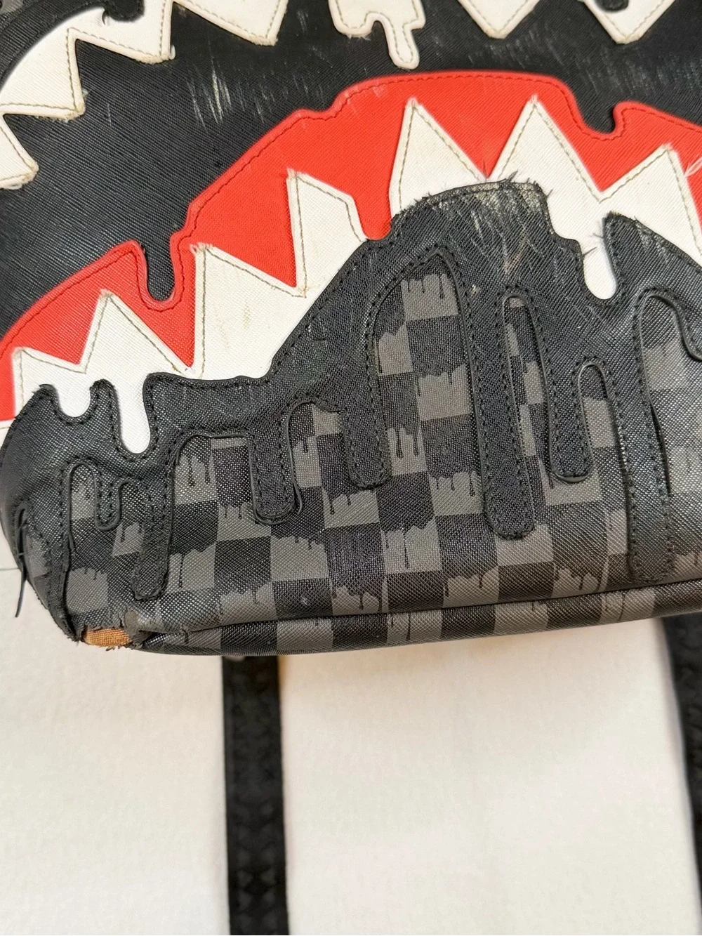 Sprayground Black Checkered Backpack with White and Red Shark Graphic